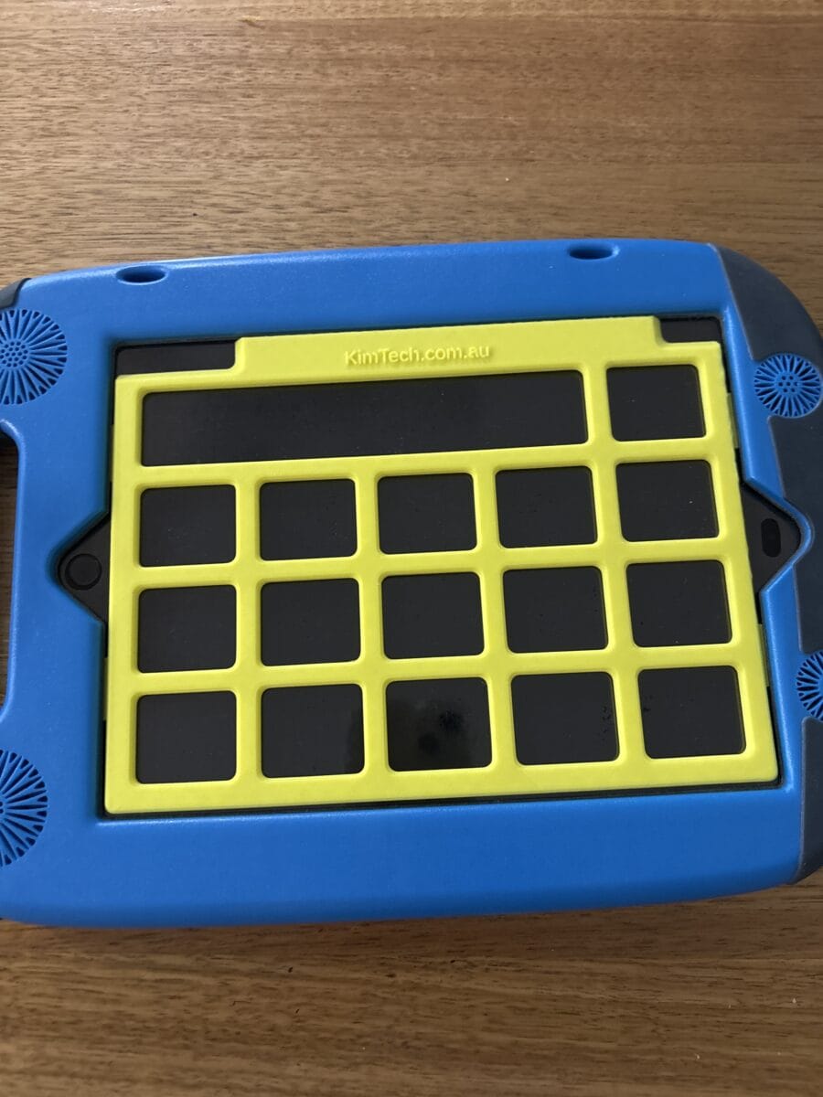 A yellow keyguard on on iPad in a GoNow case. The app displayed on the iPad is PODD 15.
