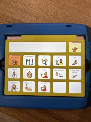 A yellow keyguard on on iPad in a GoNow case. The app displayed on the iPad is PODD 15.